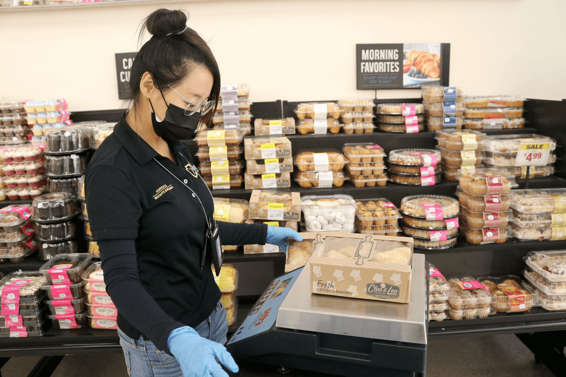 AWM Agricultural/Standards Officer weighs a boxed pie on a small scale to ensure the price marked on the box is accurate.