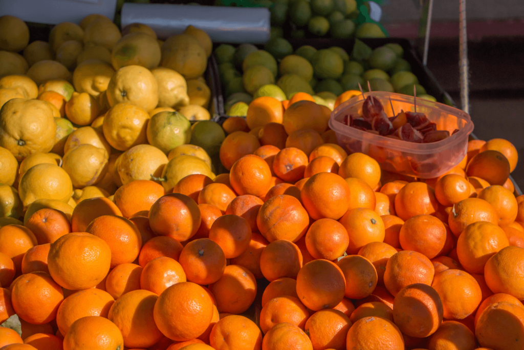 Piles of lemons, limes and oranges displayed on a table