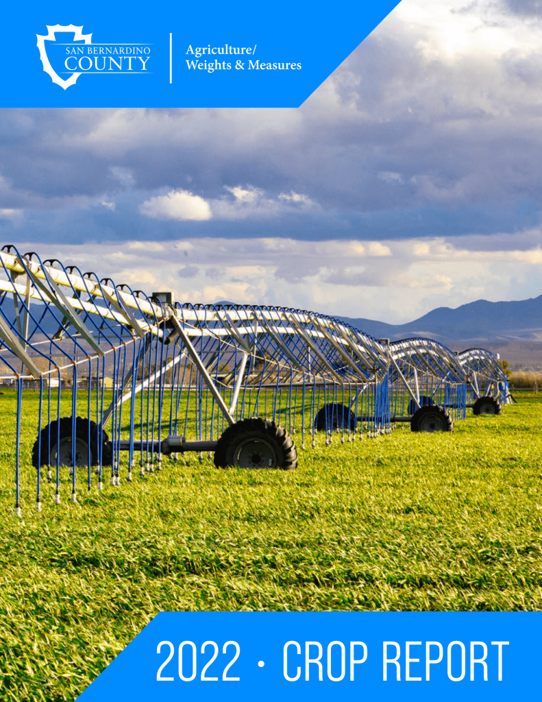 A photo of the cover of the 2022 AWM Crop Report with a a crop sprayer in a field of green grass with a mountain in the background and clouds in the sky.